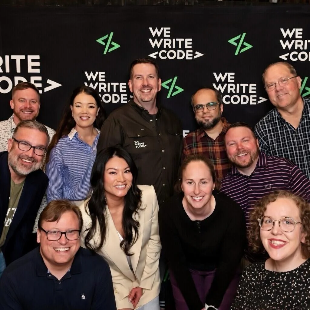 The We Write Code team in front of a branded backdrop